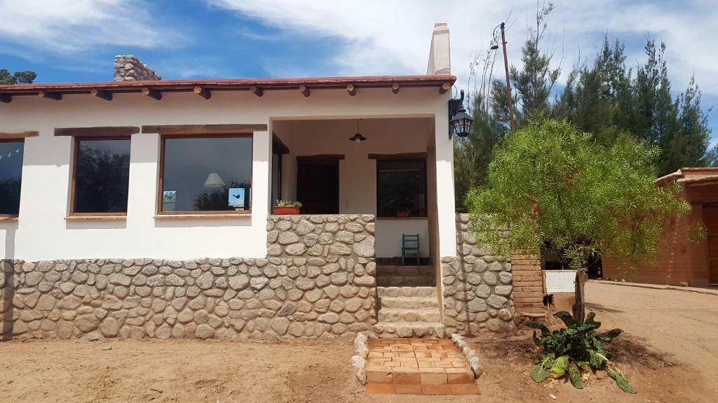 a house with a stone wall in front of it at Terraza del Molle in San Carlos