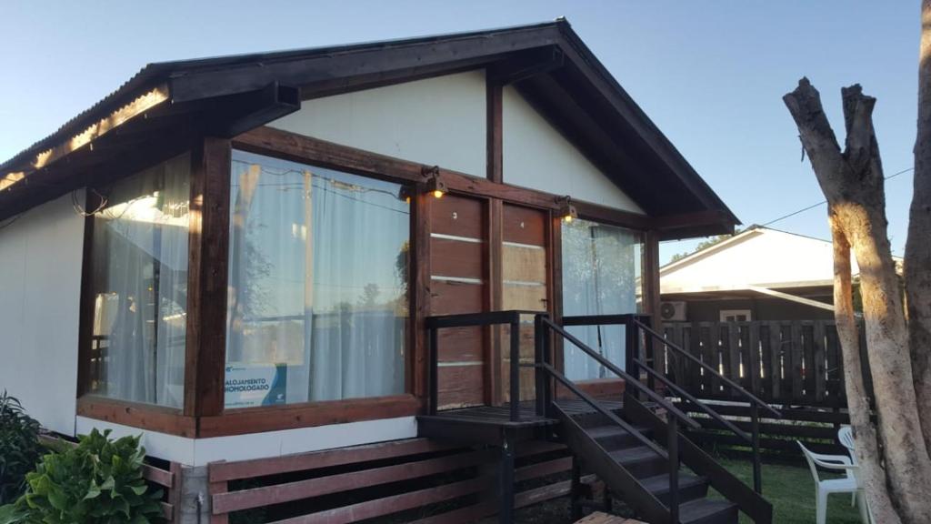 una casa pequeña con puertas de cristal y porche en Cabañas Diamante en Gualeguaychú