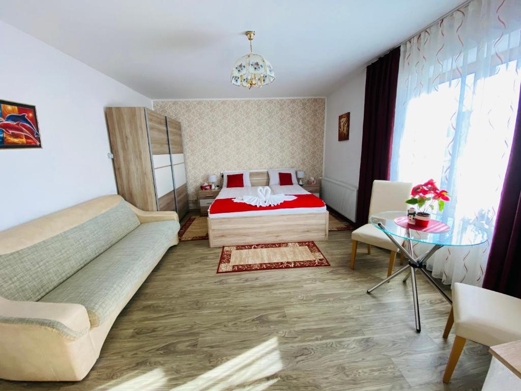 een slaapkamer met een bed, een bank en een tafel bij Casa Elena in Sibiu