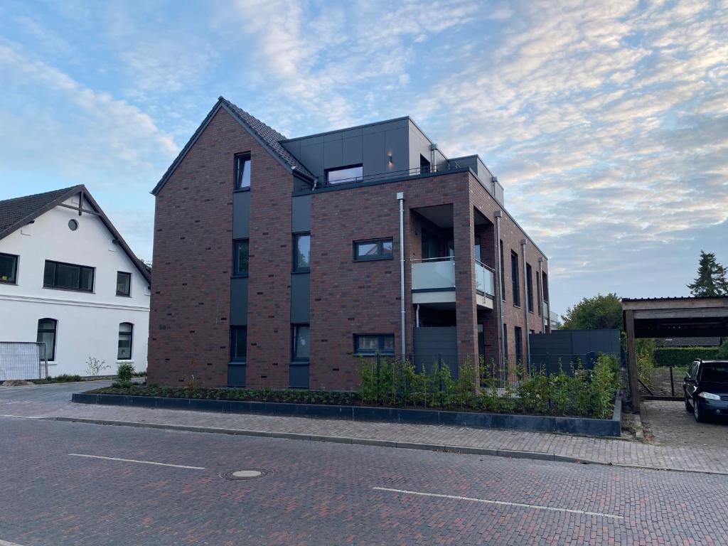 博克霍爾恩的住宿－Helle Dachgeschosswohnung in Bockhorn, LK Friesland，街道边的砖砌建筑