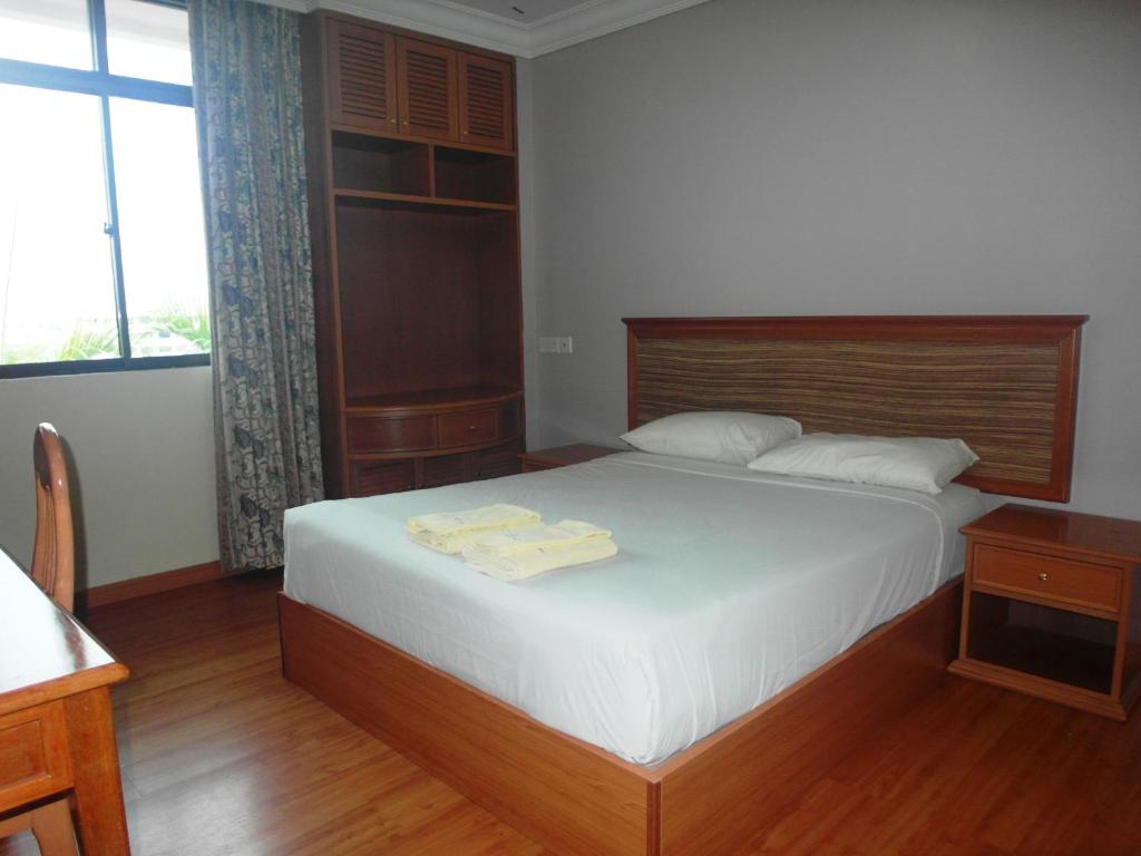 1 dormitorio con 1 cama con 2 toallas en Jinhold Service Apartment Miri, en Miri