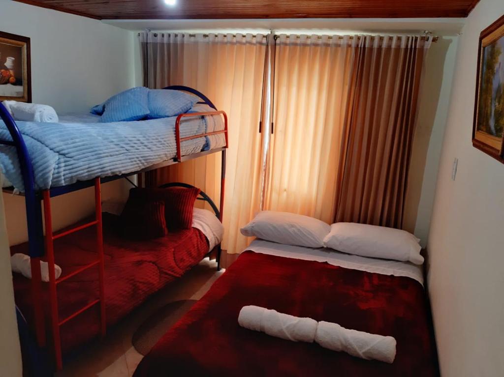 een slaapkamer met 2 stapelbedden en een rood tapijt bij Casa Adelita Paraíso Azul in Aquitania