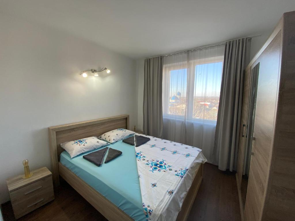 a small bedroom with a bed with a window at Apartament Sulina in Sulina