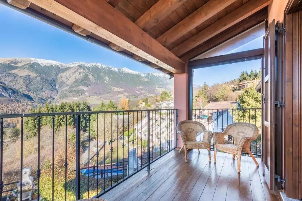 einen Balkon mit einem Tisch, Stühlen und Bergen in der Unterkunft Casa Vacanze Rosalba in Ferraro di Monte Baldo