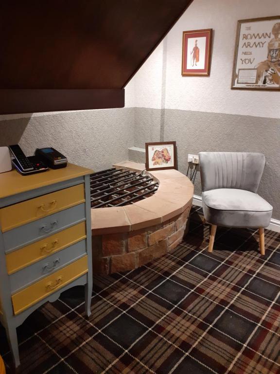 a room with a bed with a desk and a chair at Crossroads House in Carlisle