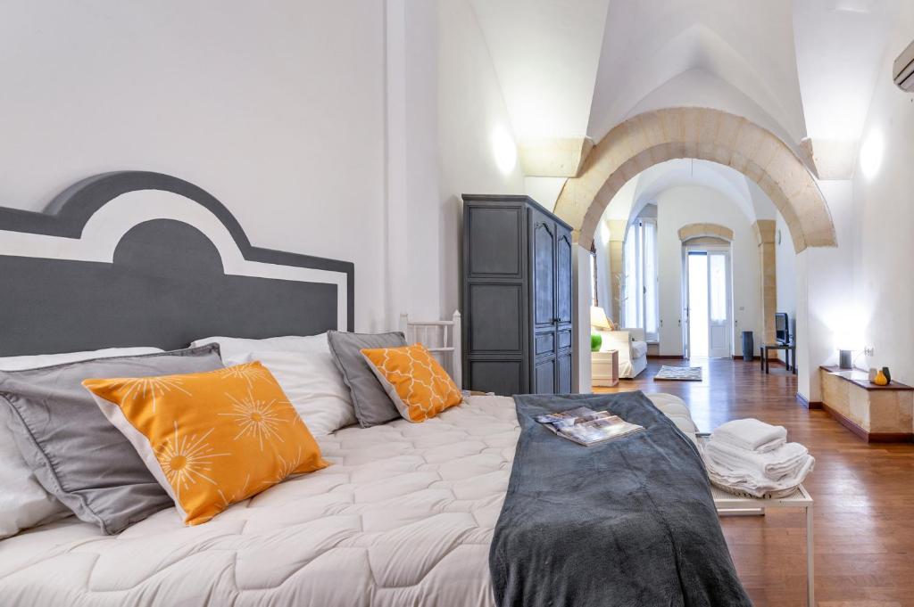 a white couch with orange pillows in a living room at Yellow Loft - Old Town Apartment SIT in Lecce