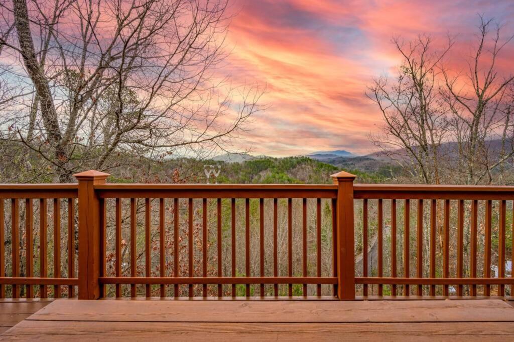 a wooden fence with a sunset in the background at OVER THE MOUNTAIN - Smoky Mountain View Cabin in Sevierville
