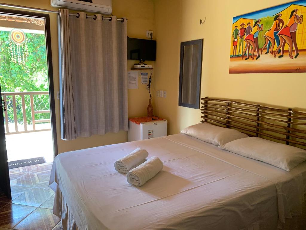 um quarto com uma cama grande e toalhas em Suítes Vimar em Jericoacoara