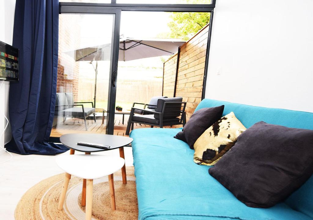 a living room with a blue couch and a table at COSY APPART - HYPER CENTRE - TRAMWAY - TERRASSE - leRelaisdOdile3 in Valenciennes