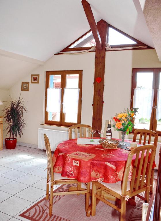 une salle à manger avec une table et des chaises rouges dans l'établissement Gîte La Maison Bleue, à Bergheim
