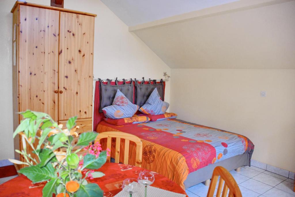 Un dormitorio con una cama y una mesa con una planta en Gîte La Maison Bleue, en Bergheim