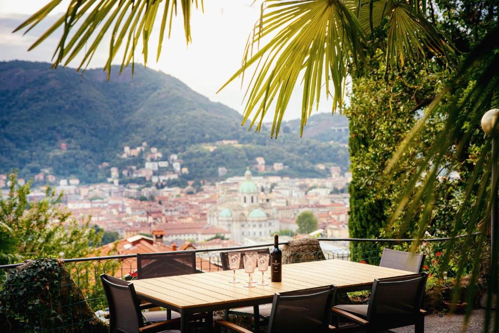 un tavolo in legno con bicchieri da vino in cima a un balcone di Villa Bertacchi - inside and out Como a Como