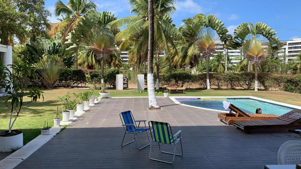 une personne assise sur une chaise à côté d'une piscine dans l'établissement Casa Branca do Paiva, à Cabo de Santo Agostinho