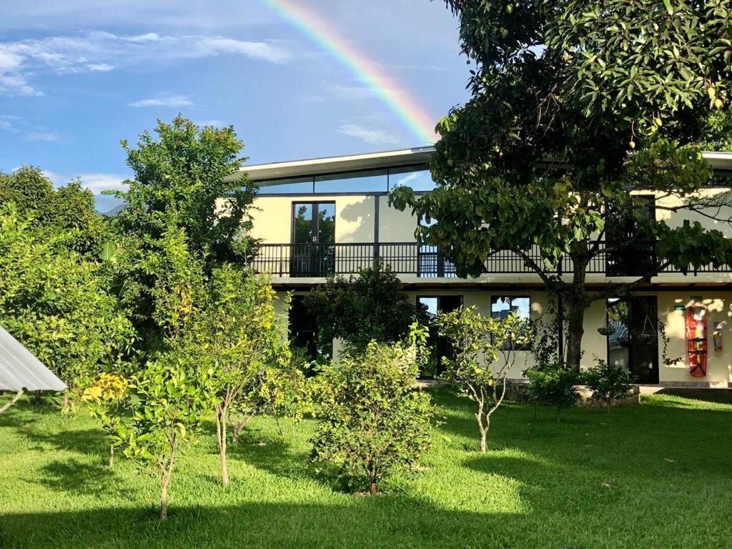 un arco iris frente a una casa con árboles en Alojamiento Rural Casa de Campo Erika Sofia, en Rivera