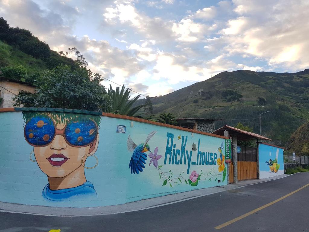 a wall with a painting of a woman on it at Ricky's House in Baños