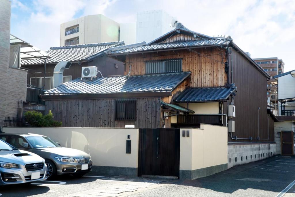 uma casa de madeira com um carro estacionado num parque de estacionamento em 阿美弥 一日一組様限定 em Quioto