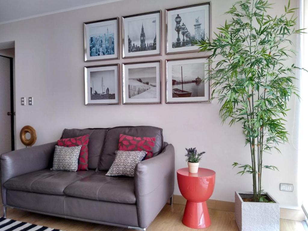 sala de estar con sofá gris y cuadros en la pared en MIRAFLORES LUXURY PLACE POOL GYM 2BD, en Lima