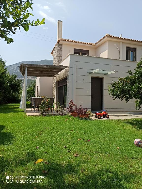 een huis met een gazon ervoor bij Aloe Apartment in Epidaurus in Oud Epidauros