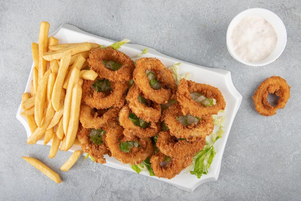 a plate of onion rings and french fries with dip at Flamingo Beach Hotel in Umm Al Quwain