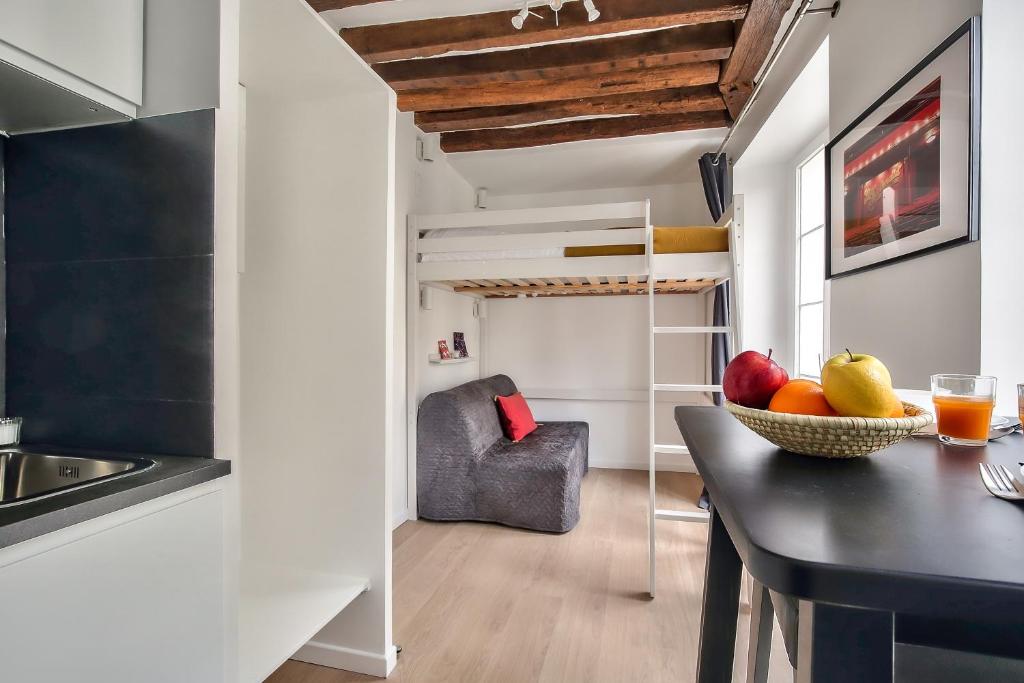 a kitchen with a table and a bowl of fruit at Lovely Mezzanine Studio in the Heart of Paris 3M in Paris