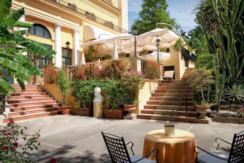 a building with stairs and plants and a table and chairs at Imperial Hotel Tramontano in Sorrento
