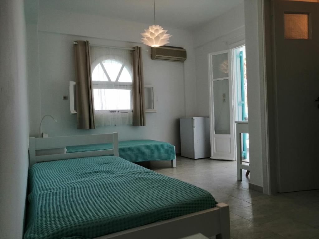 a bedroom with two green beds and a window at Aliki Panorama Rooms in Aliki