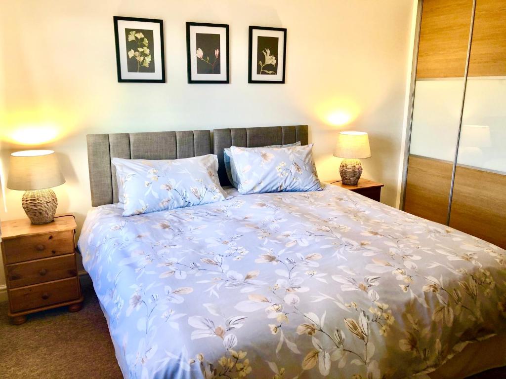 a bedroom with a large bed with blue and white sheets at Wisteria Cottages are self catering cottages in a beautiful village location in Dorrington