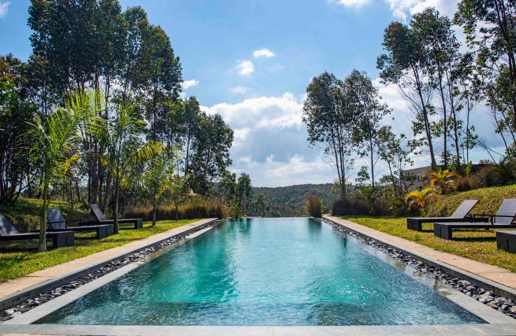 a swimming pool with blue water in a park at Mantadia Lodge Andasibe in Andasibe
