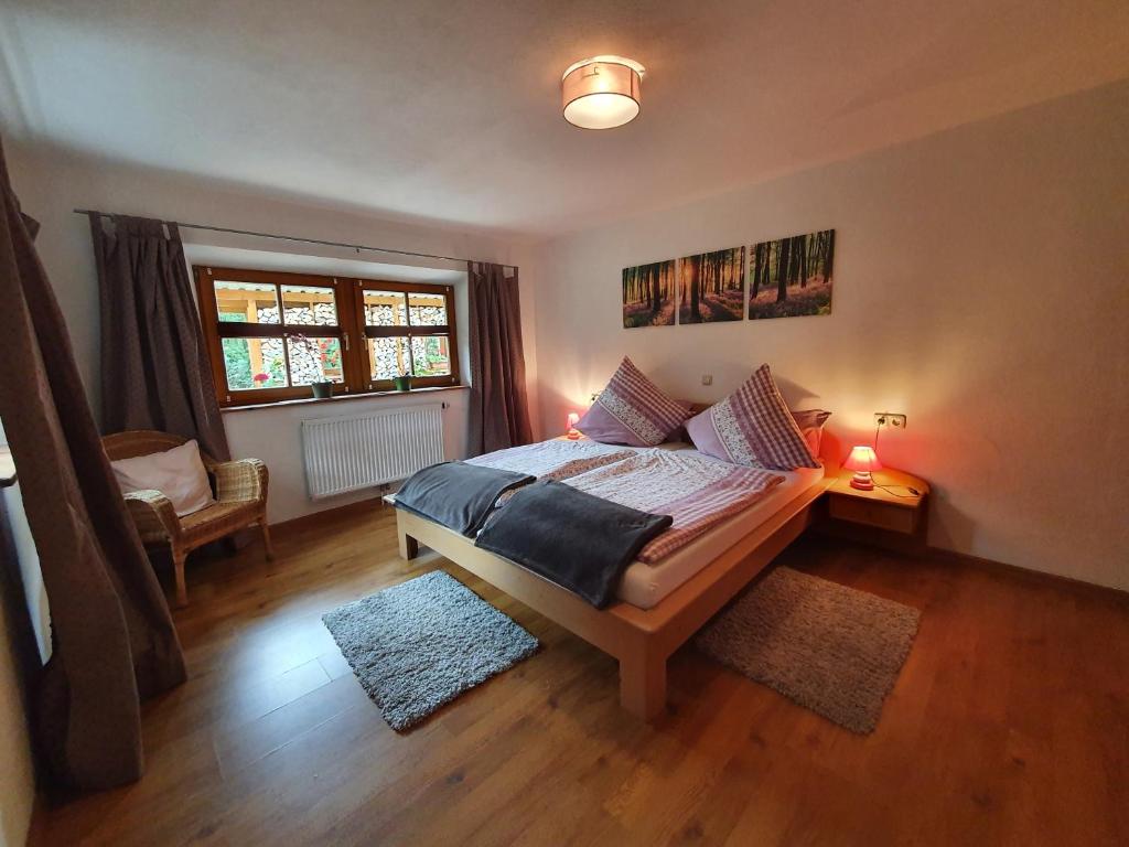 um quarto com uma cama e uma janela em Ferienwohnung Waldhäusl em Ramsau