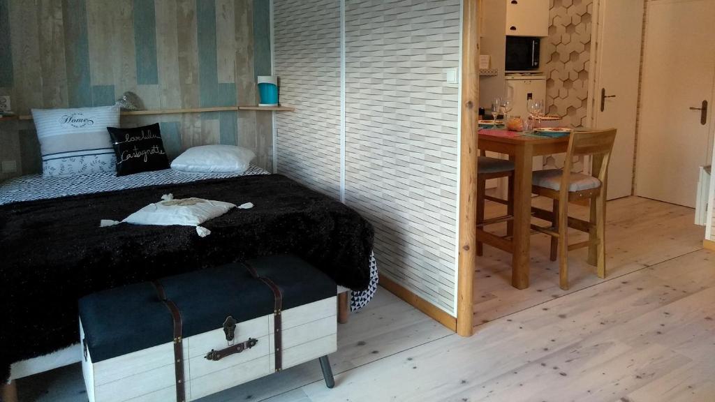 1 dormitorio con cama, escritorio y mesa en le haut village Chambre d'hôtes Mobi-Loft cosy sauna ,douche ,chromothérapie, en Arrest