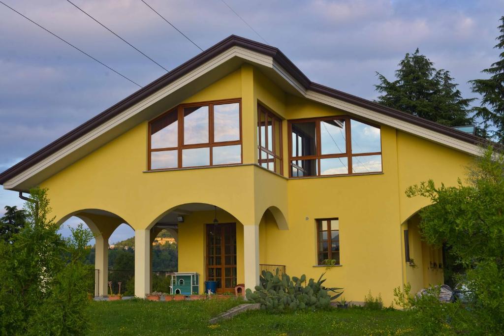 Casa amarilla con ventanas grandes en B&B Alla Roggetta, en Cremella