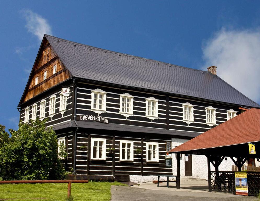 czarno-biały budynek z czarnym dachem w obiekcie Rodinný penzion Dřevěnka-Kulturni Pamatka w mieście Bozkovska