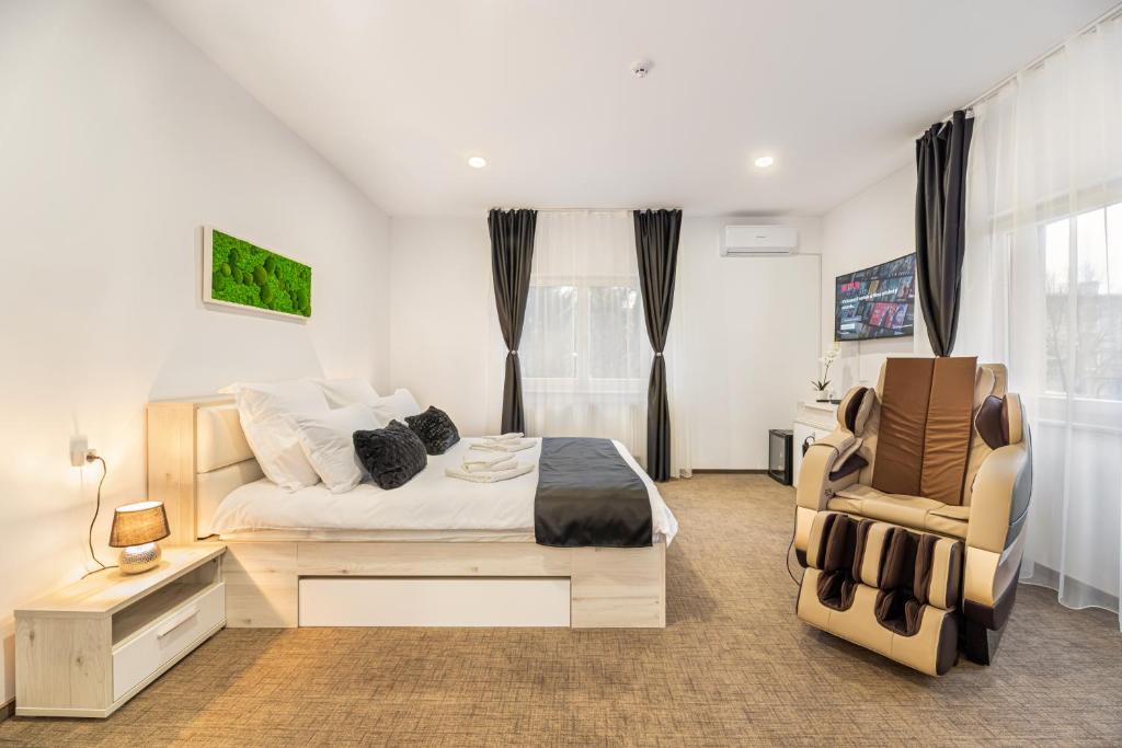 a bedroom with a bed and a chair at Bada Bing Residence in Braşov