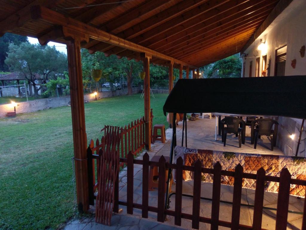 a porch of a house with a table and a fence at Invest In Rest in Vourvourou