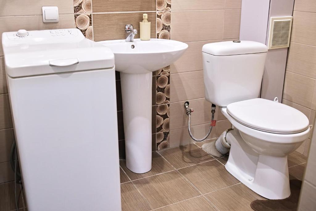 La salle de bains est pourvue de toilettes et d'un lavabo. dans l'établissement Babylon Apartments On Soborna, à Rivne