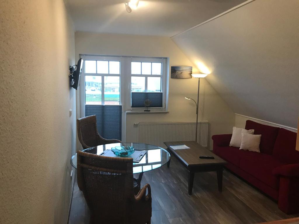 ein Wohnzimmer mit einem roten Sofa und einem Tisch in der Unterkunft Ferienwohnung Nordseegrill in Borkum
