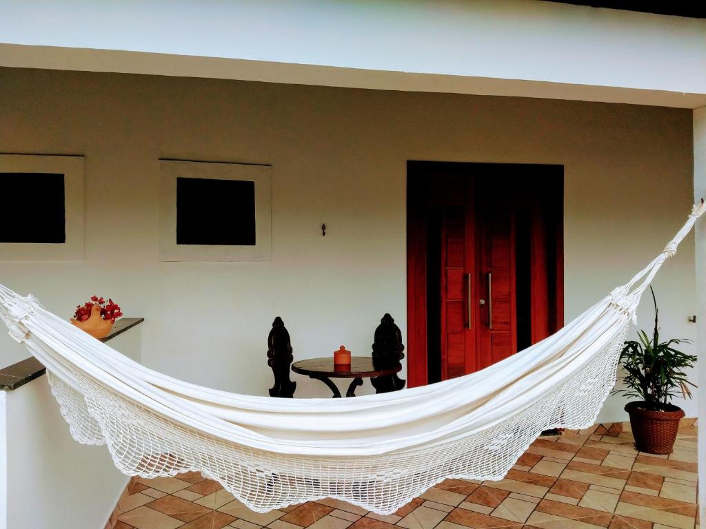 a hammock in the middle of a living room at Suítes Ninho da Águia Saquarema in Saquarema