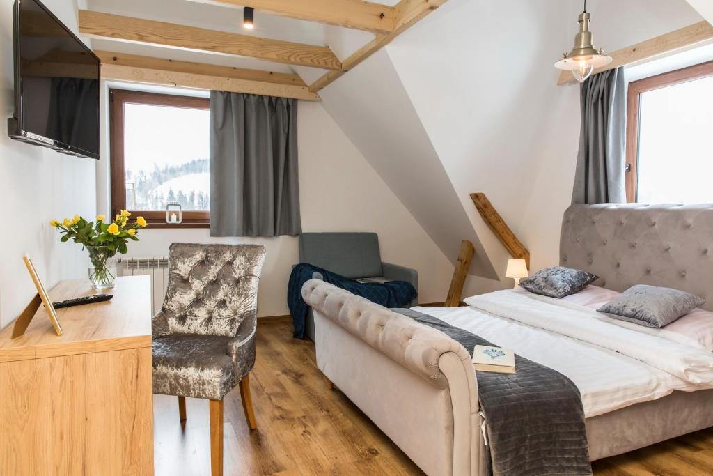 ein Schlafzimmer mit einem Bett, einem Schreibtisch und einer Couch in der Unterkunft Willa CHWOST zlokalizowana w pobliżu Term i Zakopanego in Zakopane