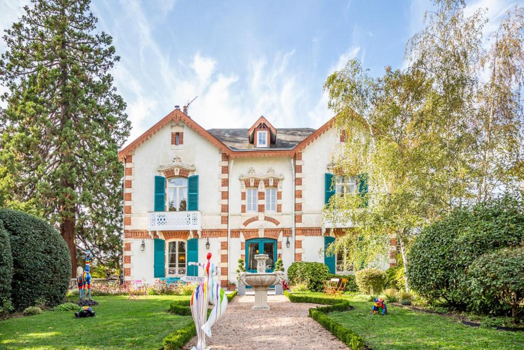 uma casa grande com um jardim em frente em L'Oustal em Bourges