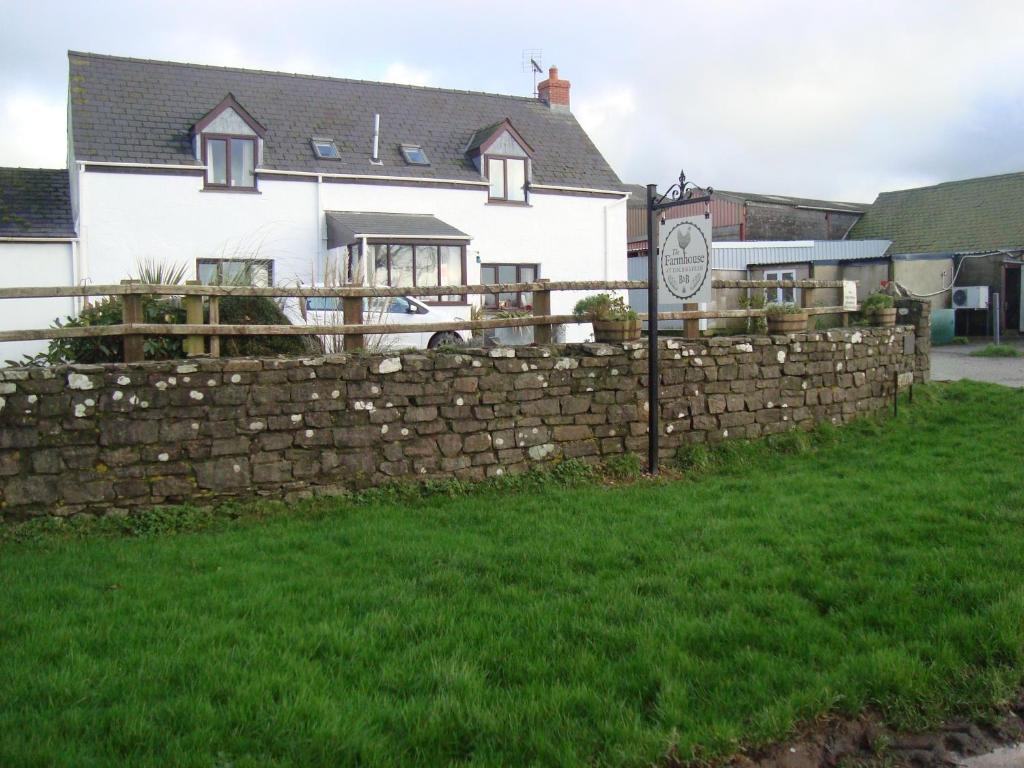 a stone retaining fence in front of a house at The Farmhouse Lochmeyler in Llandeloy
