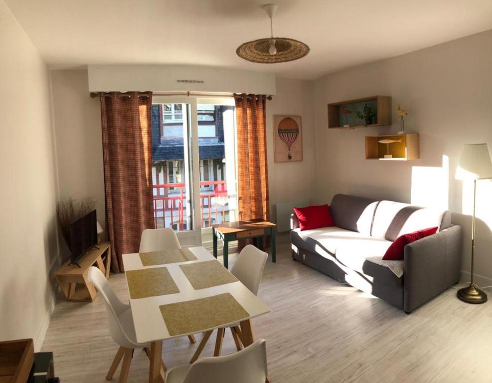 un salon avec un canapé et une table dans l'établissement Nausicaa, à Trouville-sur-Mer