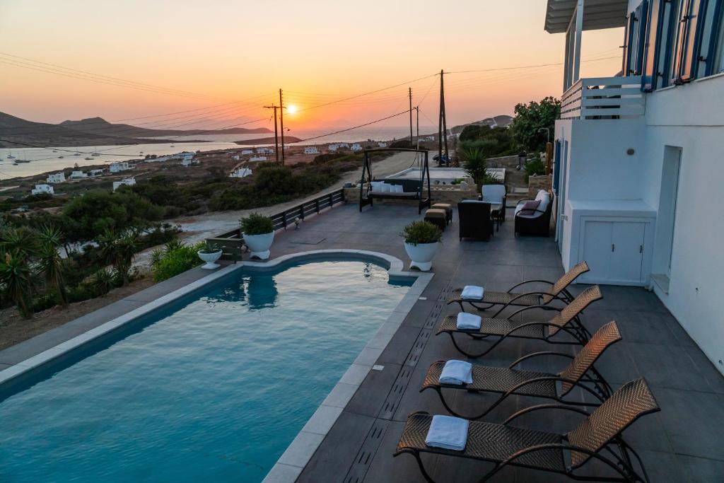 a swimming pool with chairs on a building with the beach at Villa Tani in Agios Georgios