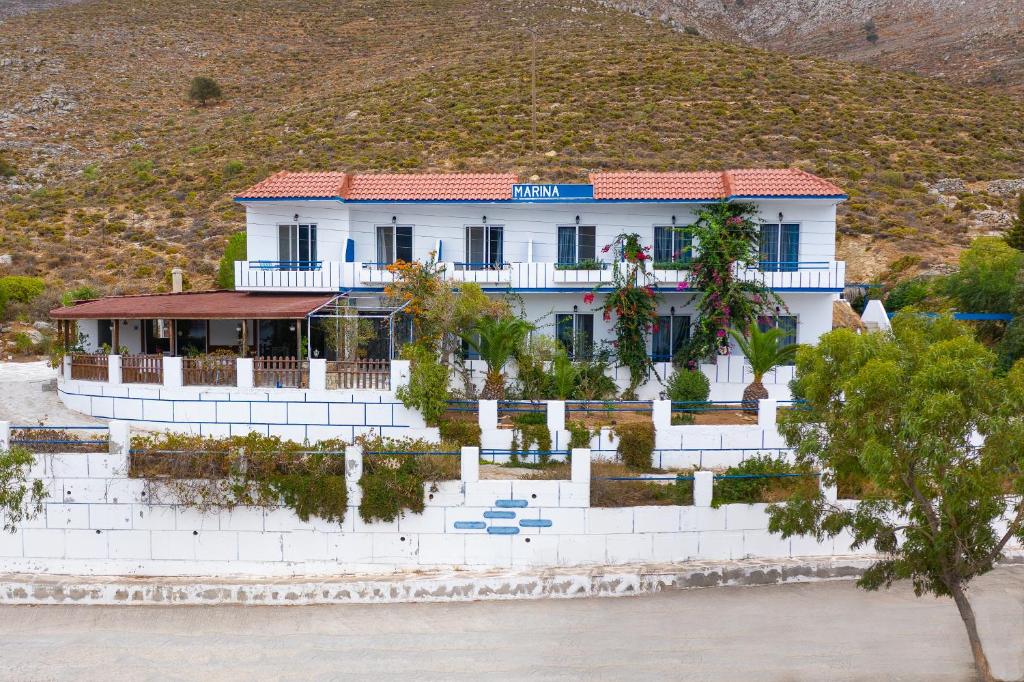 een wit huis met een heuvel op de achtergrond bij marina beach in Livadia