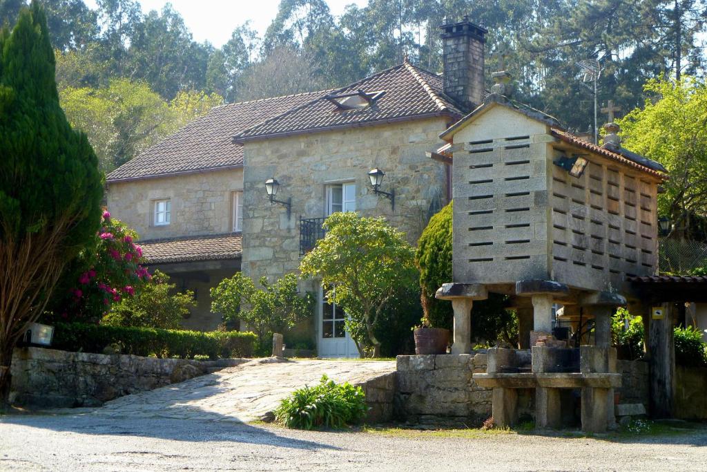 una casa con una estufa delante de ella en Casa da Posta de Valmaior, en Boiro