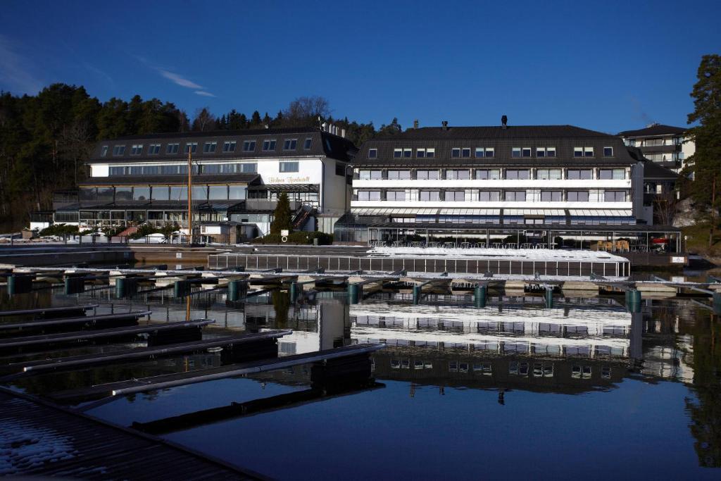 a group of buildings next to a body of water at Holmen Fjordhotell in Nesbru
