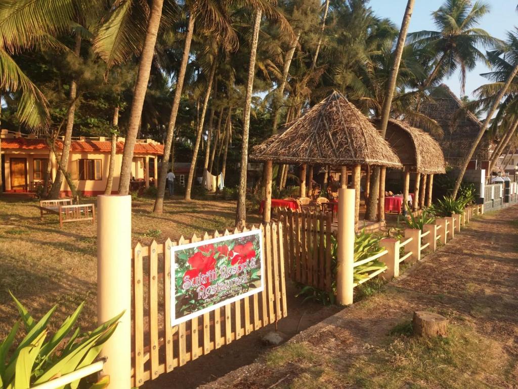 una recinzione in legno con cancello e gazebo di Sukriti beach Resort a Varkala