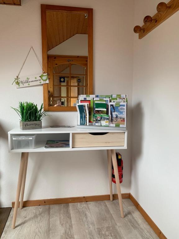 a white desk with a mirror and a table at Gästehaus Am Radweg in Blieskastel