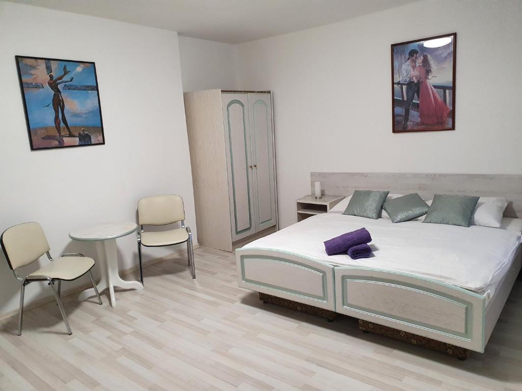 a bedroom with a bed and a table and chairs at Penzion Rafaella in Česká Kamenice