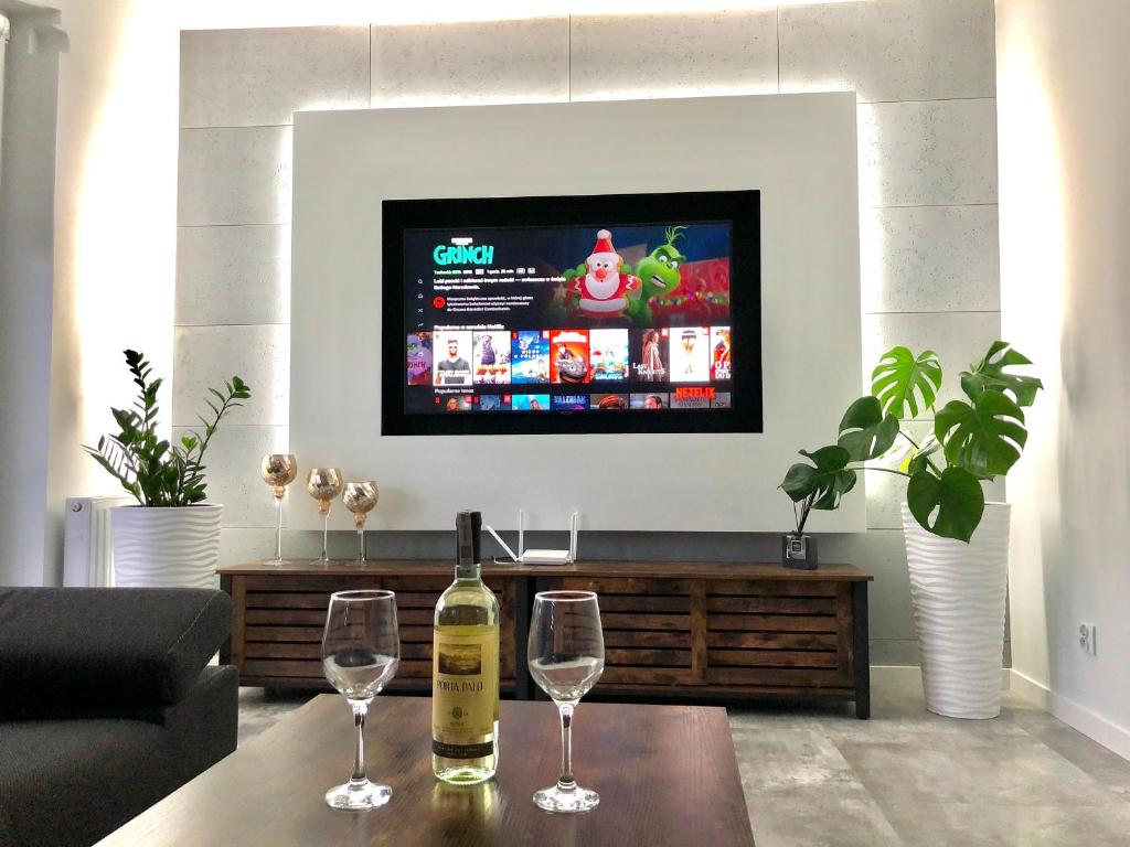 a living room with two wine glasses and a tv at Apartament Happiness in Jelenia Góra