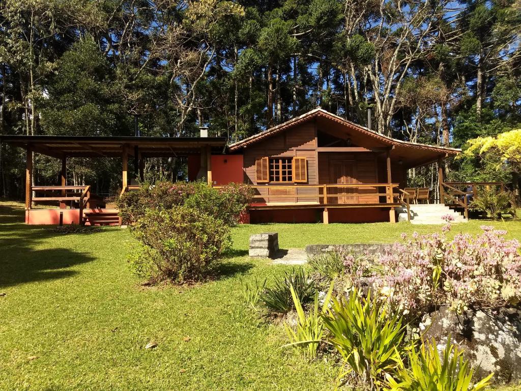 a small house in a field with a garden at Refúgio da Pedra - Casa na Montanha, Gonçalves-MG in Gonçalves